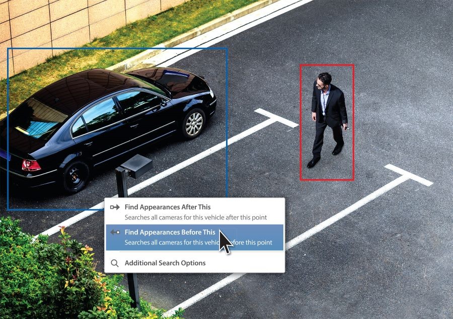 A person and car in a parking lot targeted by a video surveillance system.