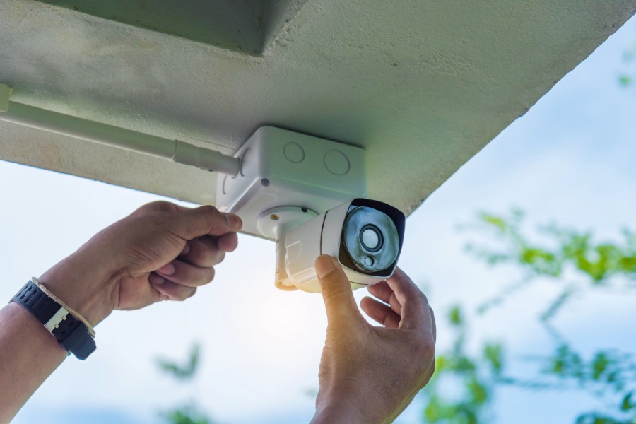 A security camera being mounted on a rooftop. 